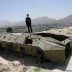 Boy on an abandoned Soviet tank near Kabul, Afghanistan