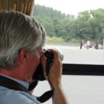 Ray Cunningham taking photos from a tour bus in North Korea